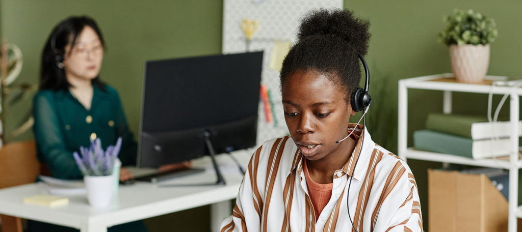Two women taking calls in an office setting